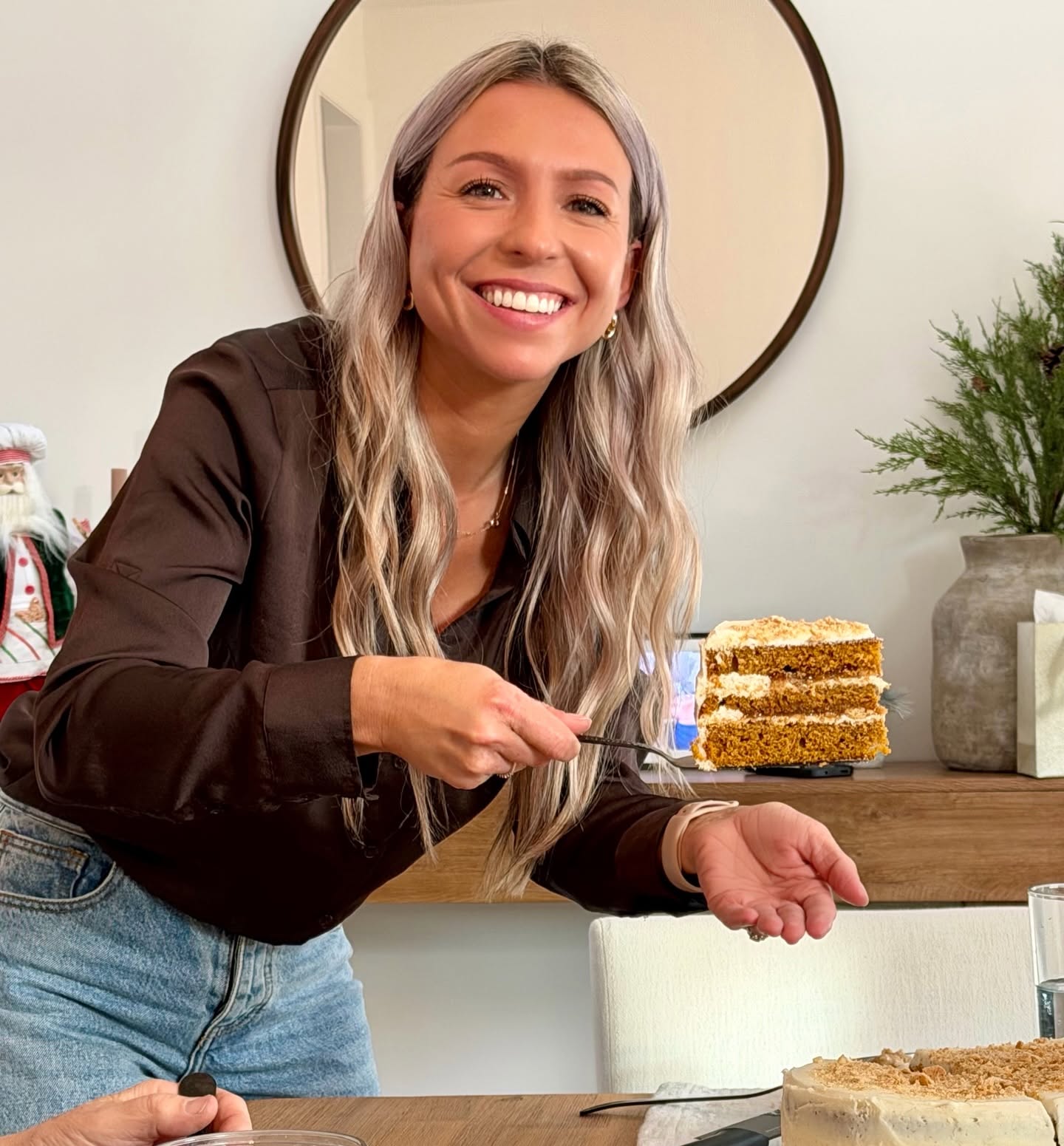 Sugar Mama baker serving a slice of layered cake